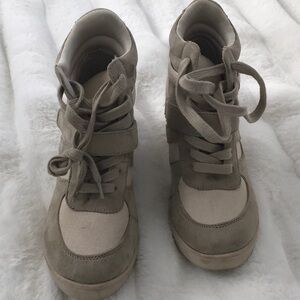 High-top,tan-colored sneakers with a hidden wedge heel and velcro strap accents